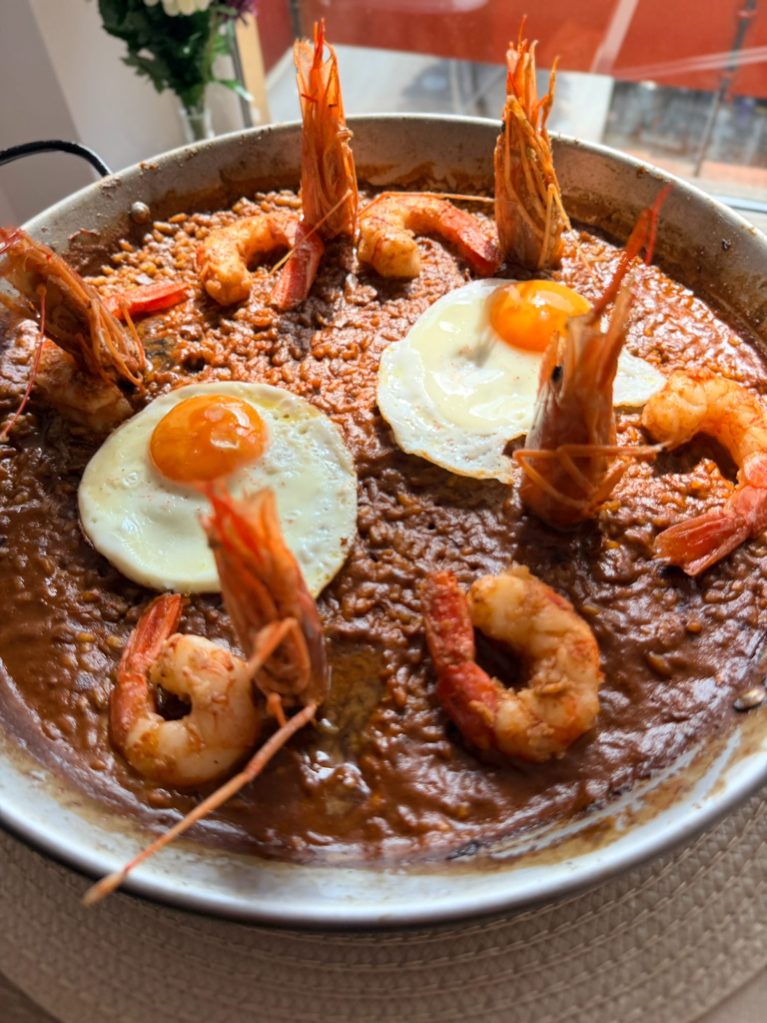 Arroz meloso de marisco con huevo frito y langostinos, emplatado por el chef Óscar Gamboa