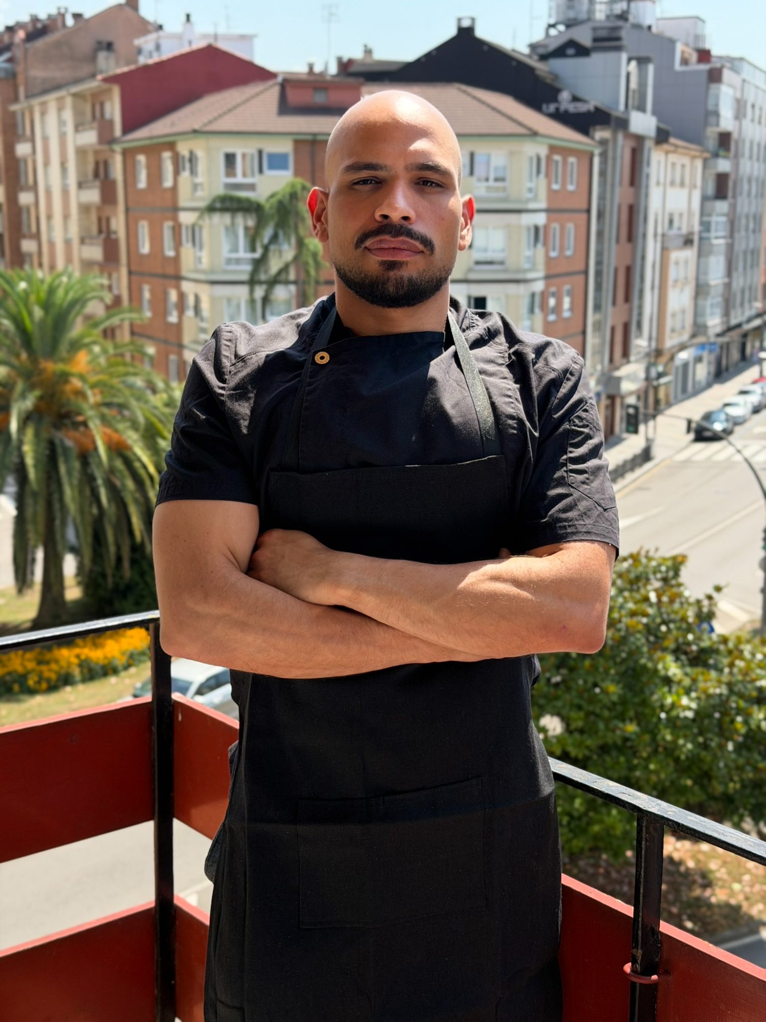 Retrato del chef Óscar Gamboa con chaquetilla y delantal negros
